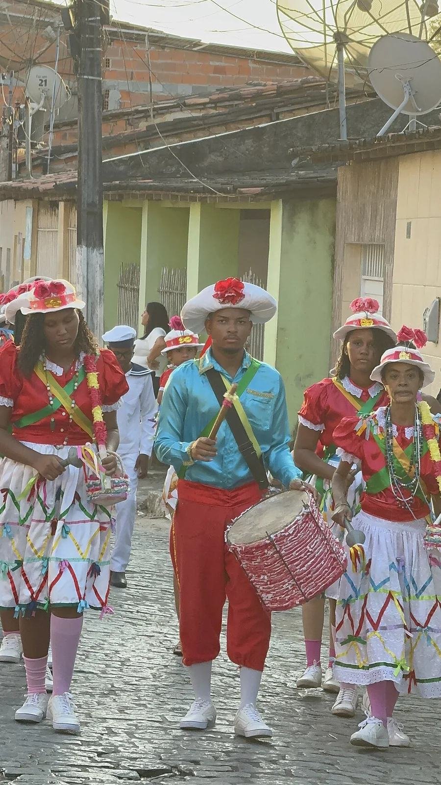Grupo das Taieiras de Laranjeiras em cortejo com roupas coloridas e tambor
